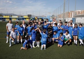 Los niños de Espíritu Deportivo y algunas leyendas del Málaga levantan el trofeo conmemorativo en el campo de la Unión Deportiva Dos Hermanas-San Andrés.