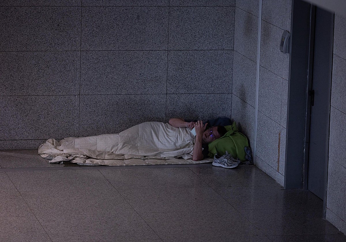 Persona sintecho acostada en un rincón de la T3 del aeropuerto de Málaga.