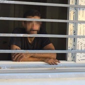 El detenido, mientras esperaba a los bomberos en el piso en el que fue sorprendido.