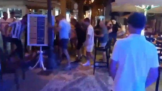 Un grupo de personas retiene al presunto agresor, anoche en la céntrica plaza Cavana de Nerja.