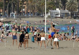 Turistas y residentes disfrutan en una playa de Málaga.
