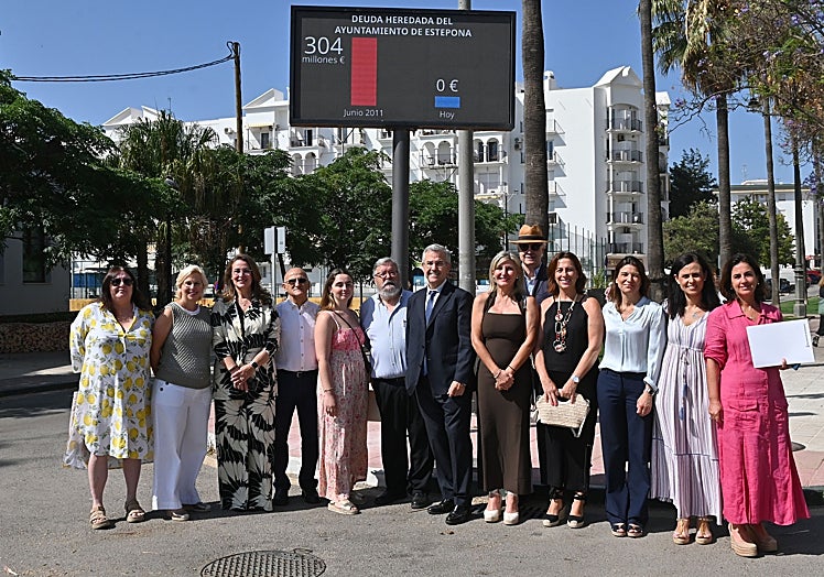El regidor con parte de su equipo de gobierno ante el marcador de la deuda.