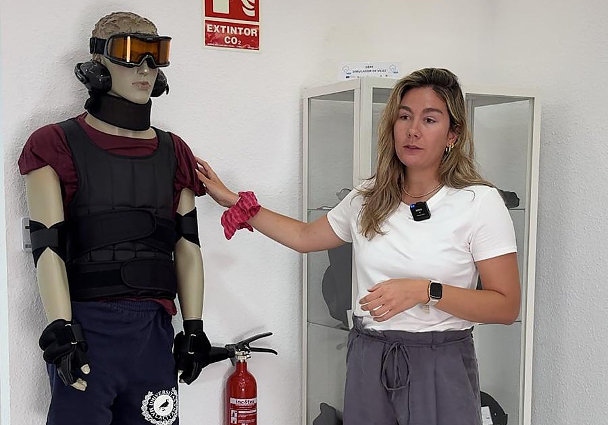 Marina Soler, trabajadora social del proyecto, junto al traje del programa Vivir en Casa.