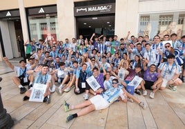 Los participantes de la búsqueda del tesoro posan delante de la tienda del Málaga en Calle Larios.