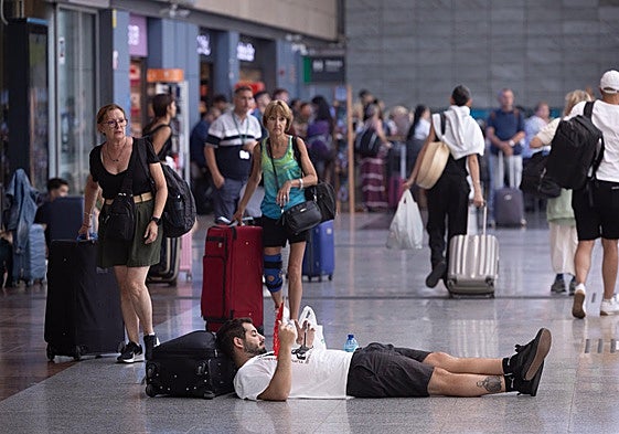 Un viajero espera tumbado en la estación María Zambrano de Málaga.