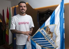 Joaquín posa junto a la bandera del Málaga tras firmar su nuevo contrato.
