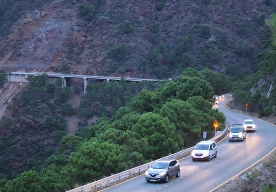Los primeros coches pasan por la carretera ya abierta.