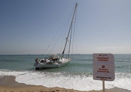 La imagen muestra el velero varado en la playa de la Garrofera.