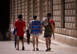 Turistas se dirigen hacia la playa por el centro de la capital.