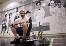 Ángel Idígoras, sentado sobre los botes de pintura, con los primeros personajes de su nuevo mural cinéfilo.