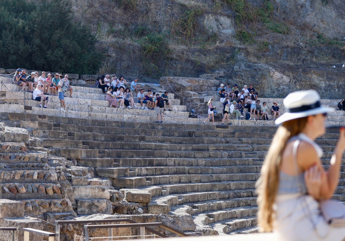 Turistas contemplan y disfrutan del Teatro Romano en Málaga.