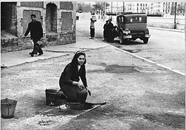 Mujer cogiendo agua de un registro en El Perchel. Archivo Municipal de Málaga