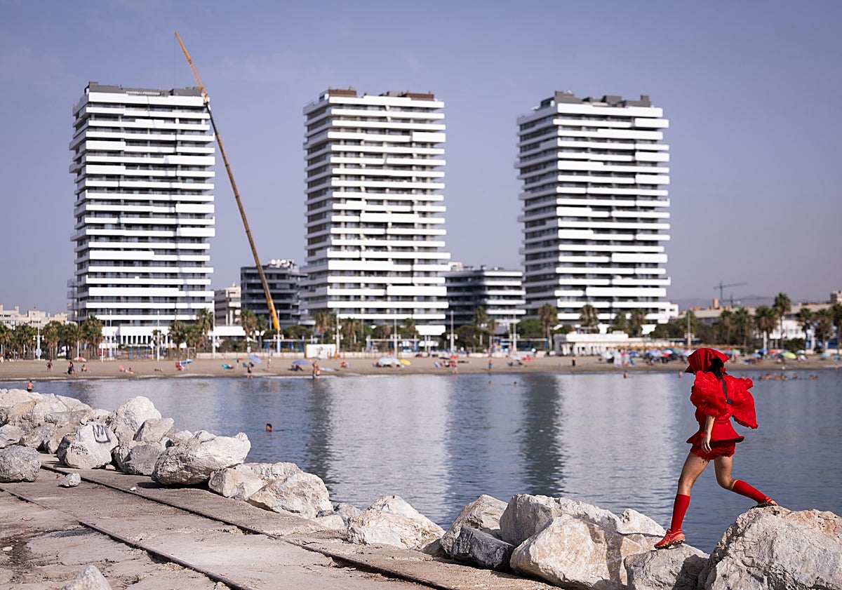 Imagen principal - ¿Quién es la mujer de rojo que cruza las playas de Málaga?