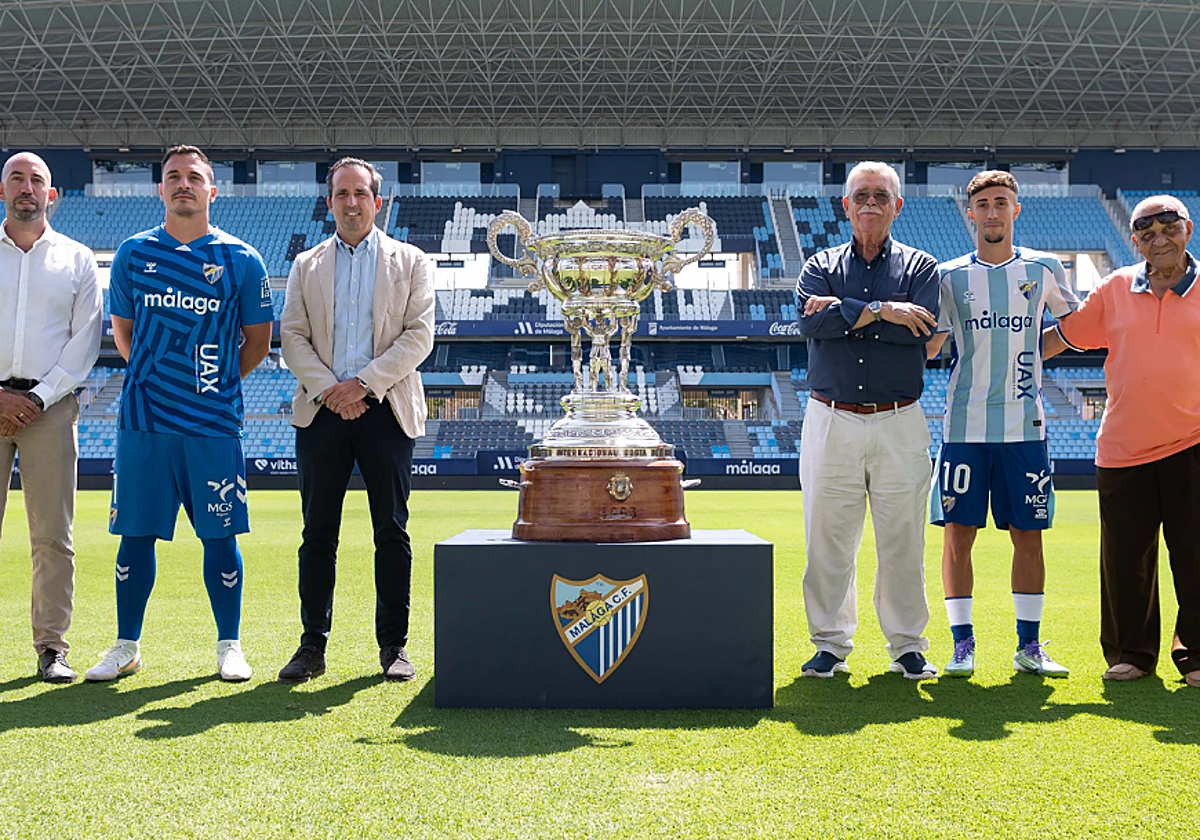 Dirigentes del Málaga y los futbolistas Alfonso Herrero y Larrubia, junto al trofeo del Costa del Sol.