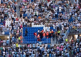 Las asistencias médicas, llevándose en camilla al aficionado afectado.