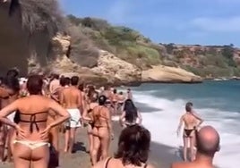 Imagen de bañistas observando la actuación de los socorristas en la playa nerjeña de Burriana.