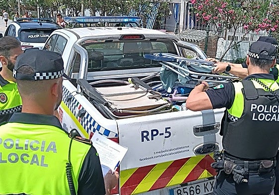 Agentes de la Policía Local, en una actuación contra las ocupaciones de playa en primera línea con sillas y sombrillas.