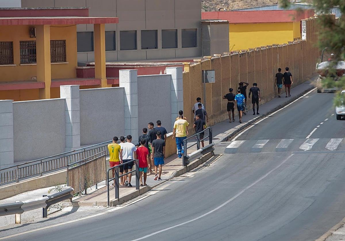 Menores migrantes caminan junto a un centro de acogida en la ciudad autónoma de Ceuta.