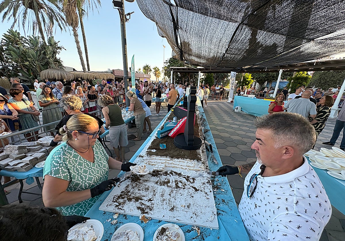 Colas para recoger su porción de tarta gigante gratuita, este jueves en el paseo marítimo de Torre del Mar.