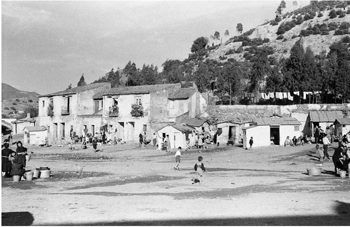 1952. Plazuela de Santa María, Mundo Nuevo. Málaga. En el lateral izquierdo de la imagen, fuente de agua potable de la que se nutre el poblado. En el de la derecha, lavadero público.