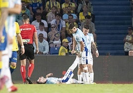 Montero ayuda a Puga a estirar su pierna derecha, con Murillo detrás.