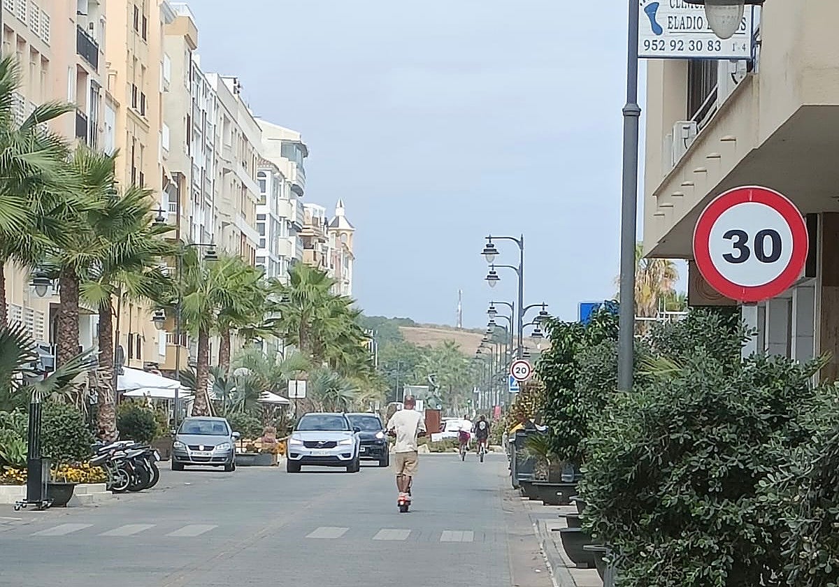 Una persona en patinete por la Avenida de España de Estepona.