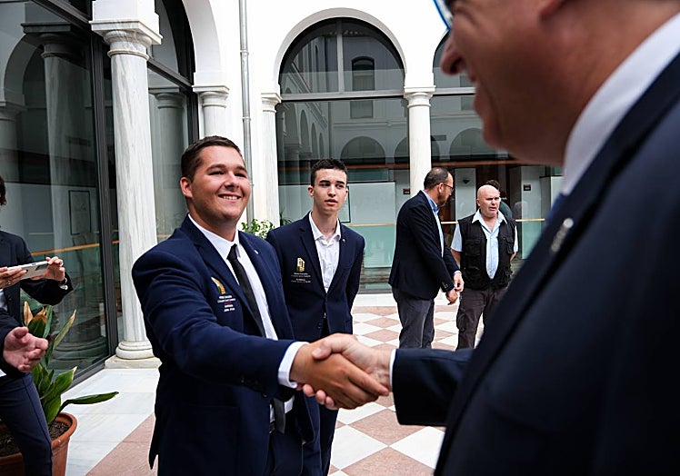 Un alumno del Hotel Escuela Convento Santo Domingo de Archidona saluda al consejero de Turismo, Arturo Bernal.