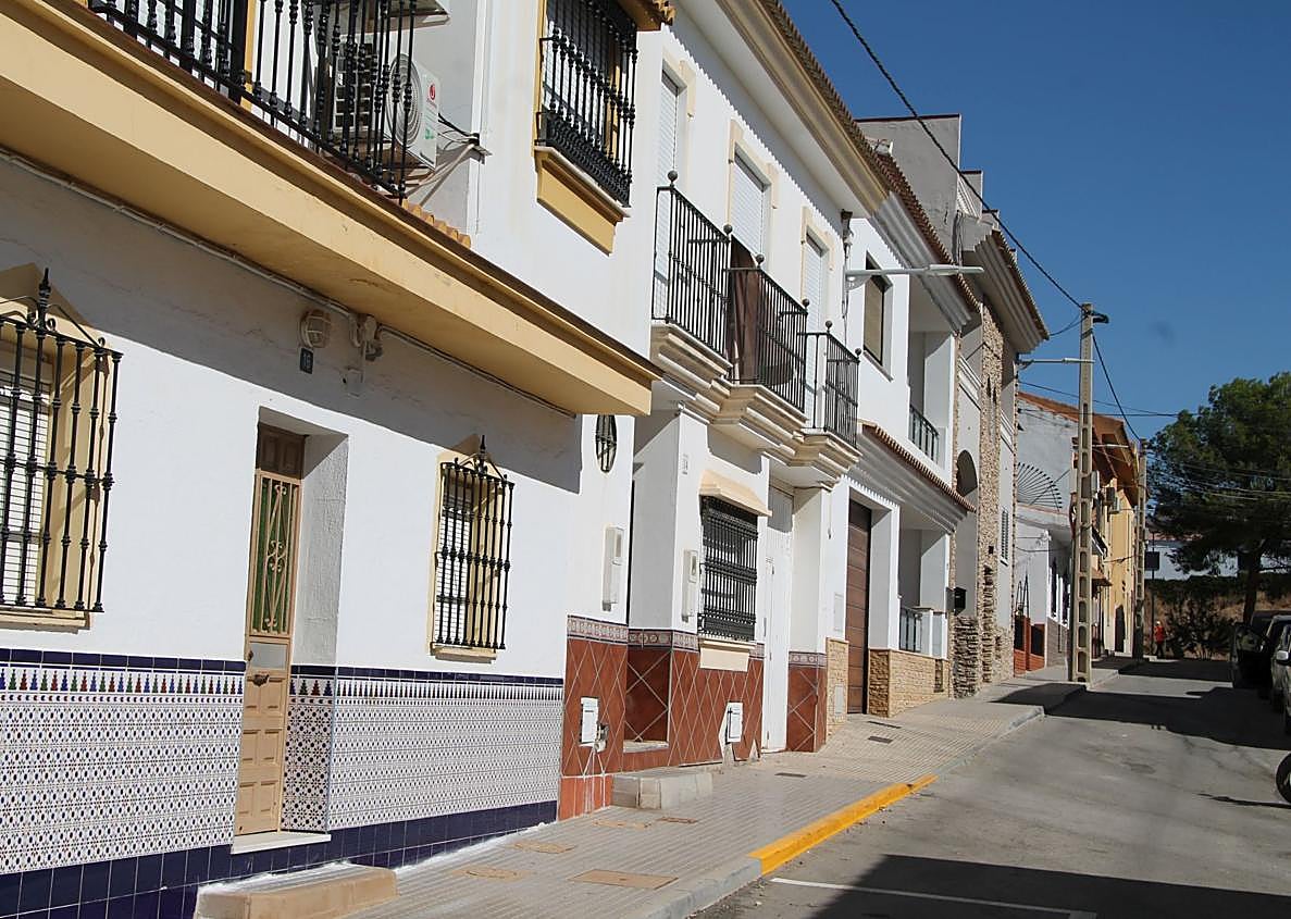 Imagen secundaria 1 - Mosaico en la entrada del casco urbano que alude a los verdiales. Abajo, una de las calles del centro de esta aldea y paseo dedicado a 'Panseco'.