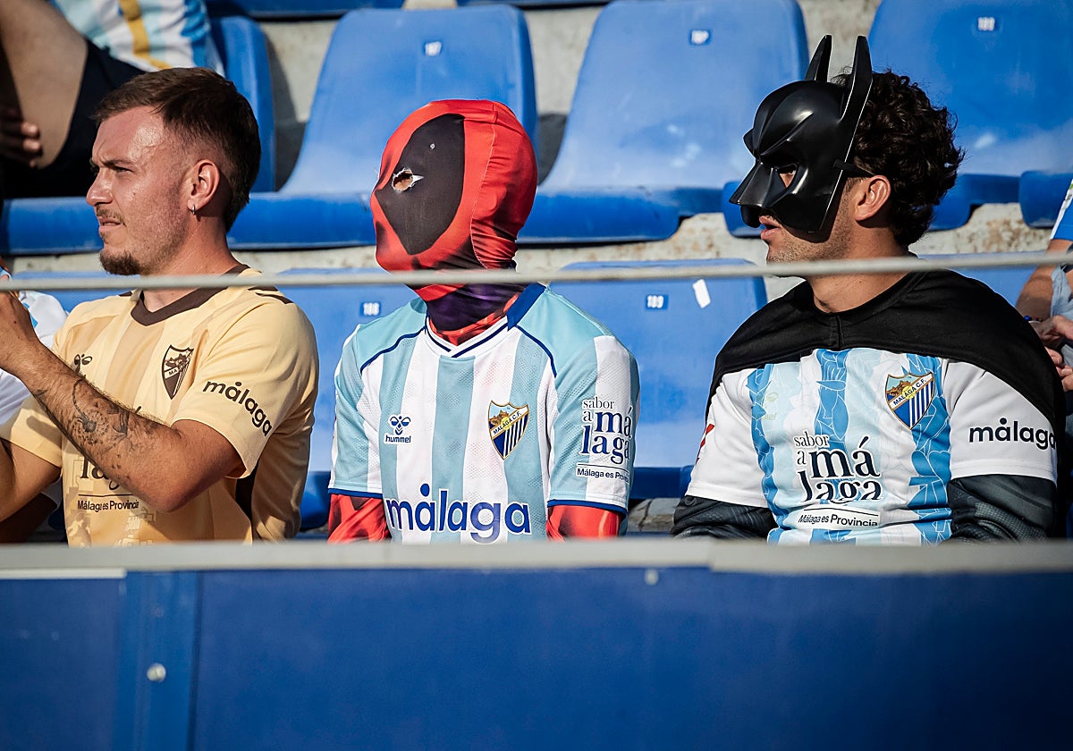 Aficionados del Málaga, disfrazados de Deadpool y Batman, en El Alcoraz el pasado sábado.