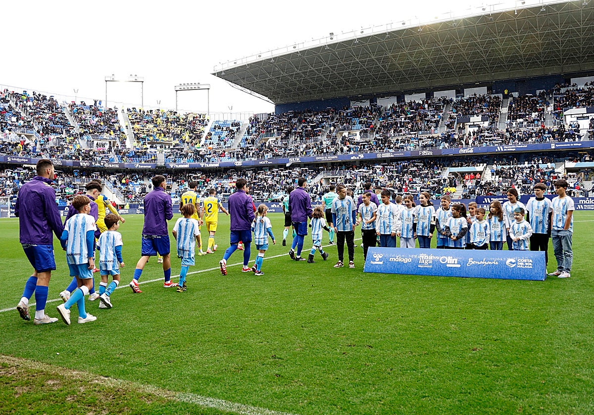 La salida de los equipos al campo, en el último Málaga-Cádiz liguero marcado por la lluvia.
