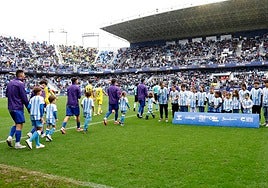 La salida de los equipos al campo, en el último Málaga-Cádiz liguero marcado por la lluvia.