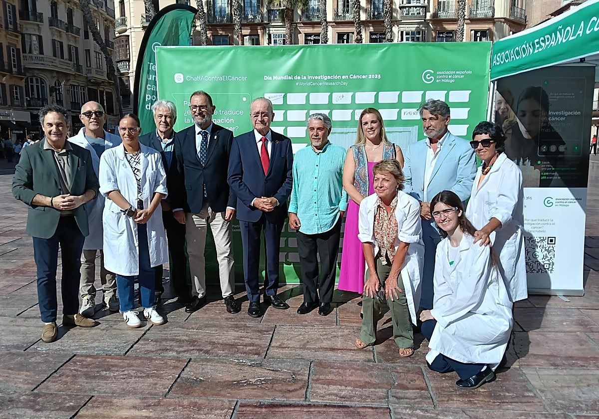 Autoridades políticas, investigadores y voluntarios posan juntos para conmemorar el Día Mundial de la Investigación en Cáncer.