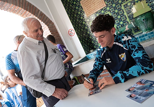 Aarón Ochoa firma un autógrafo a un aficionado malaguista.