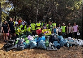 Los participantes posan con las bolsas de residuos retirados.
