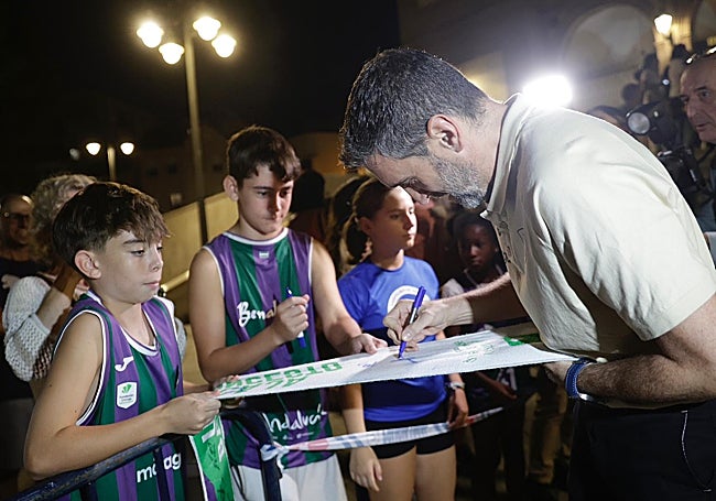 Ibon Navarro le firma una bufanda a un joven aficionado.