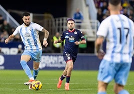 Álex Pastor busca dar un pase a un compañero, con David Mella replegando, en el último Málaga-Deportivo.