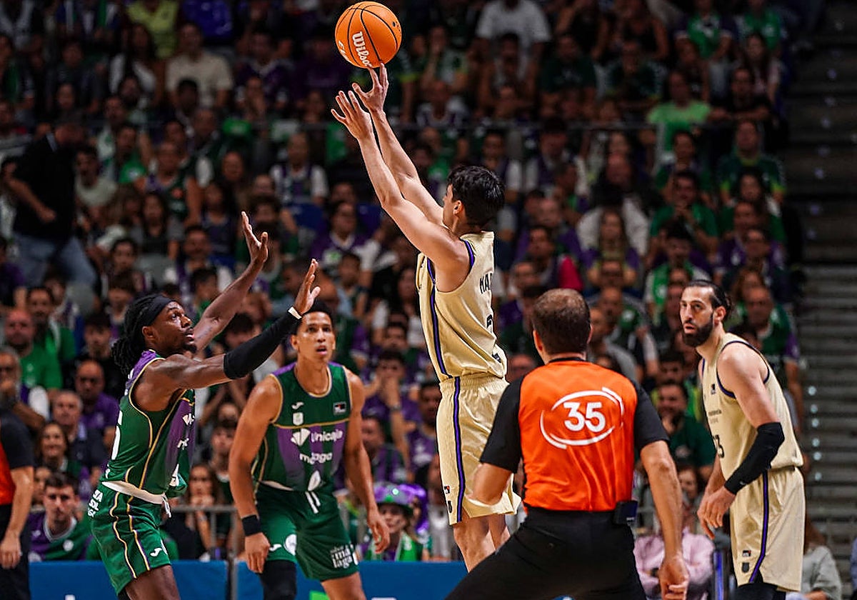 Juani Marcos lanza un triple ante Perry ante la mirada del colegiado Emilio Pérez Pizarro.