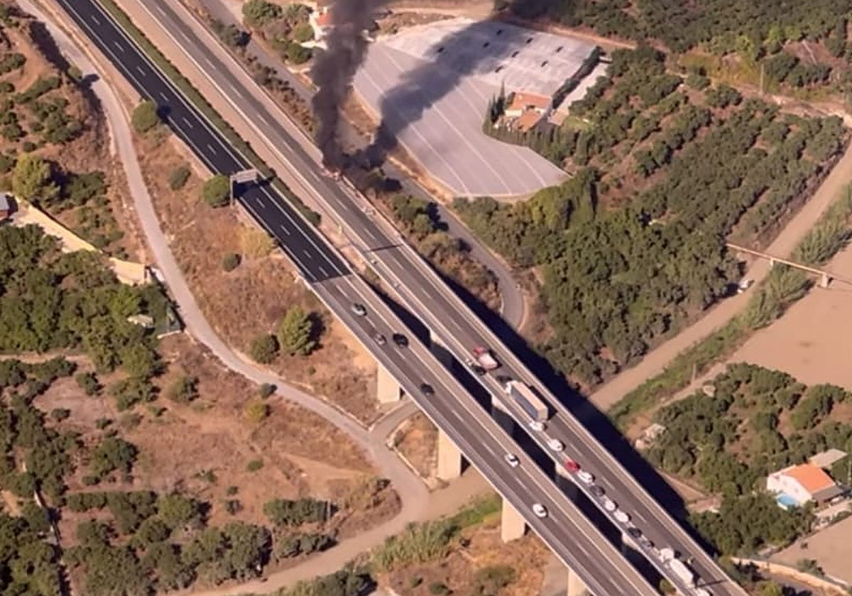 Imagen aérea del vehículo incendiado este viernes en la autovía a la altura de Nerja.