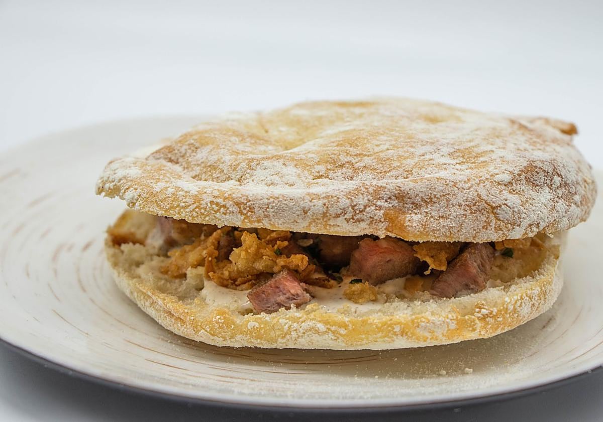 Imagen principal - Mollete de presa ibérica a la parrilla de El Lagar de Verum. Campero malagueño de pollo aliñado de La Terraza de Solecio. Mollete de panceta ibérica y huevo de codorniz de Tragabuches. 