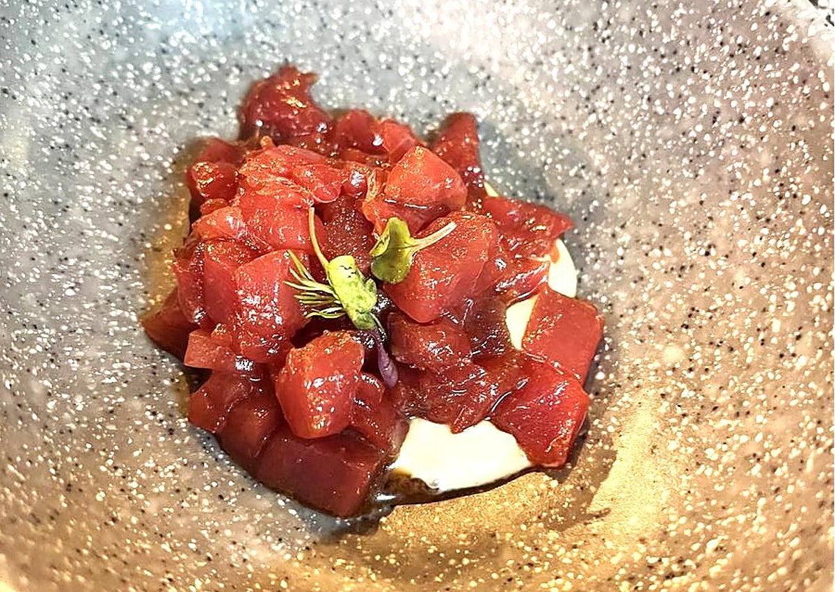 Imagen secundaria 1 - Arriba, el sumiller junto a una muestra de algunas de sus botellas. Abajo, tartar de atún con gazpachuelo y vieira con gazpacho de naranja. 