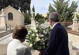 Una de las nietas del arquitecto, María Victoria García Guerrero-Strachan, junto al alcalde de la ciudad, Francisco de la Torre, ante la tumba.