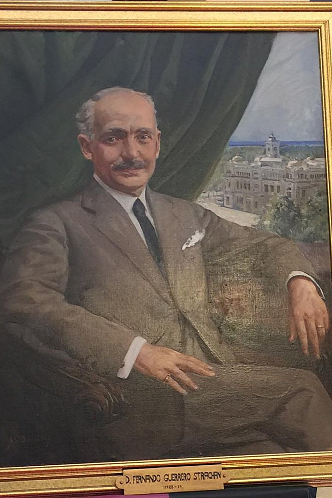 El retrato de Guerrero Strachan es peculiar porque de ser hoy día podríamos decir que es como un selfie, en el que él aparece dominando la escena, y detrás, la Casona del Parque, de su autoría. Está en la galería de alcaldes. en la primera planta.