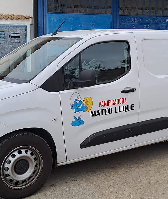 Imagen secundaria 2 - Arriba, Silvestre Luque, en la panadería antes de jubilarse. Abajo, Antonio Cárdenas, fundador de La Canasta, y furgoneta de Mateo Luque con la imagen del pitufo y el bollito de pan.  