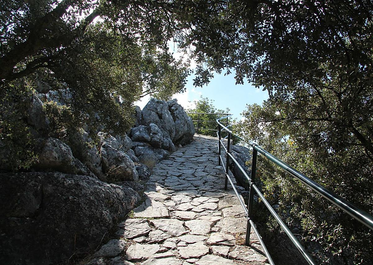 Imagen secundaria 1 - En la primera foto, Escultura que preside el mirador. Camino empedrado para recorrer este enclave (foto 2). Vista panorámica de El Burgo desde el mirador (foto 3).