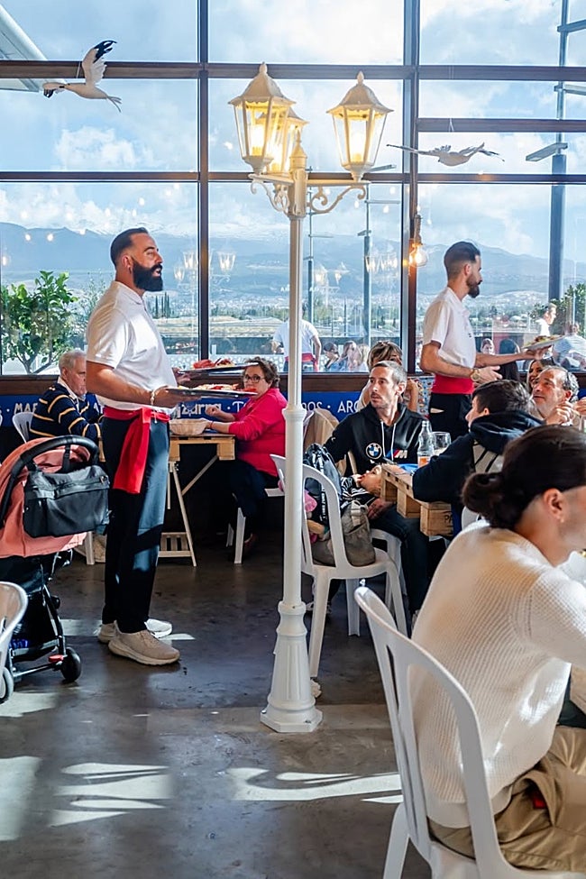 Camareros cantan los platos en el local del centro comercial Nevada de Granada.