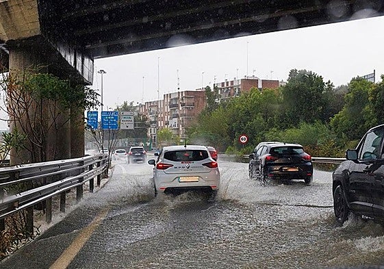 Vehículos transitan bajo una fuerte lluvia.