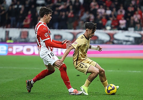 Larrubia protege el balón en el último Sporting-Málaga, la temporada pasa en El Molinón.