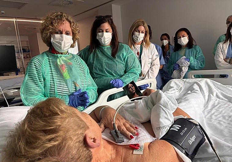 Camareras de la Esperanza reparten pañuelos de la Virgen entre los enfermos del Hospital Clínico