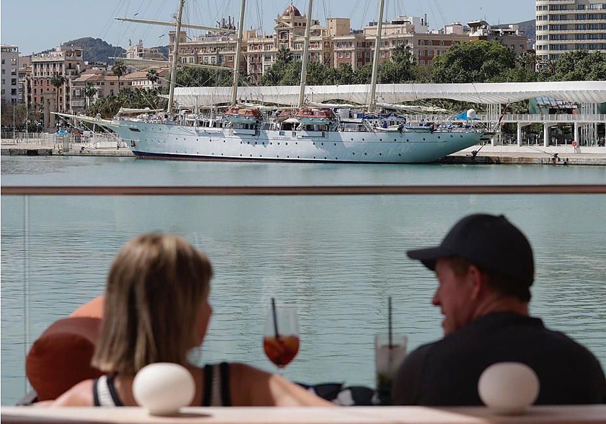 Turistas toman un refresco en una terraza del Muelle Uno de la capital de la Costa del Sol.