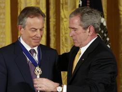 Momento en el que George W. Bush  impone la condecoración al ex primer ministro británico Tony Blair durante la ceremonia que se ha celebrado en la Casa Blanca. /Reuters